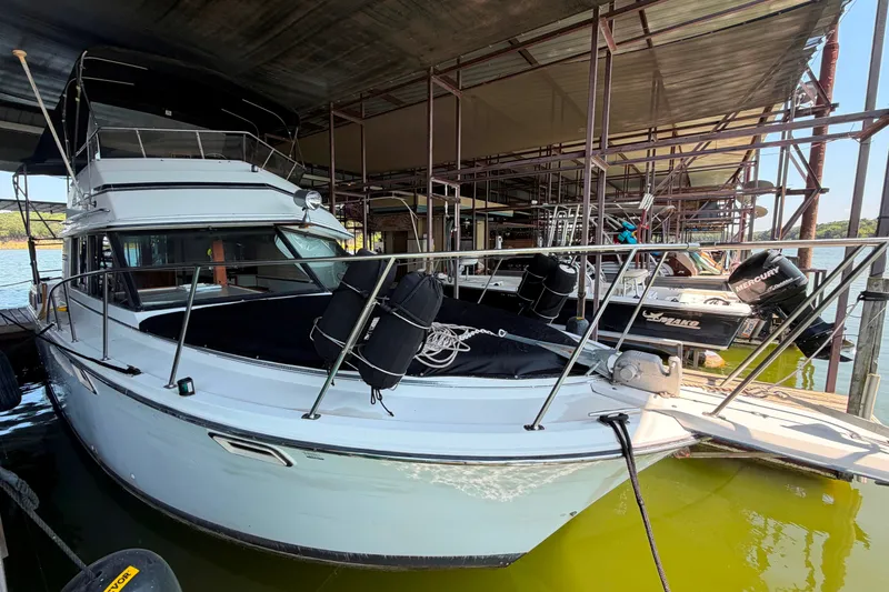 The Image of 1987 Carver 32 Aft Cabin Motor Yacht docked under a covered marina. - 3