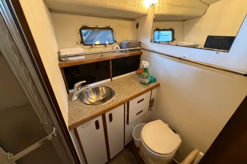 Slide: The Image of Bathroom interior of 1987 Carver 32 Aft Cabin Motor Yacht, featuring sink and toilet. - 33