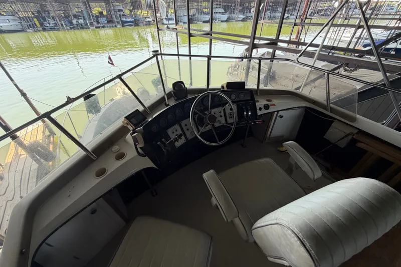 Slide: The Image of Interior helm of 1987 Carver 32 Aft Cabin Motor Yacht with marina view. - 16