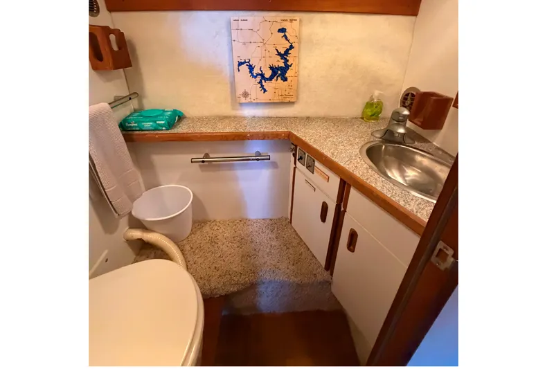 Slide: The Image of 1987 Carver 32 Aft Cabin Motor Yacht bathroom with sink, toilet, and map decor. - 39