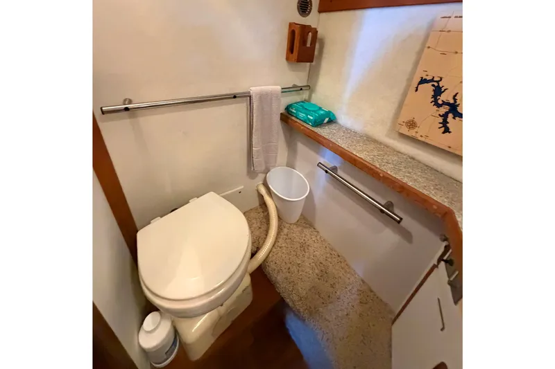 Slide: The Image of 1987 Carver 32 Aft Cabin Motor Yacht bathroom with toilet, towel rack, and storage shelf. - 40