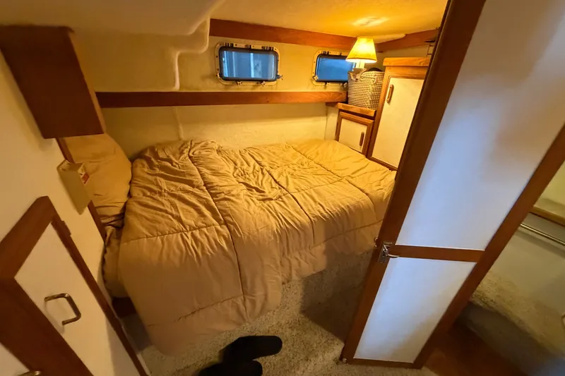 Slide: The Image of Cozy bedroom in 1987 Carver 32 Aft Cabin Motor Yacht with warm lighting and wood accents. - 35