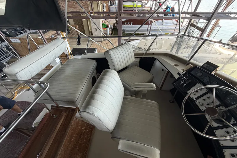 Slide: The Image of 1987 Carver 32 Aft Cabin Motor Yacht helm with seating and control panel. - 14