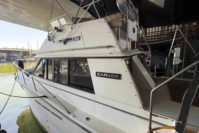 Slide: The Image of 1987 Carver 32 Aft Cabin Motor Yacht docked in a marina, showcasing its classic design. - 7