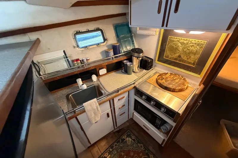 Slide: The Image of Compact kitchen in 1987 Carver 32 Aft Cabin Motor Yacht with stove, sink, and decor. - 25
