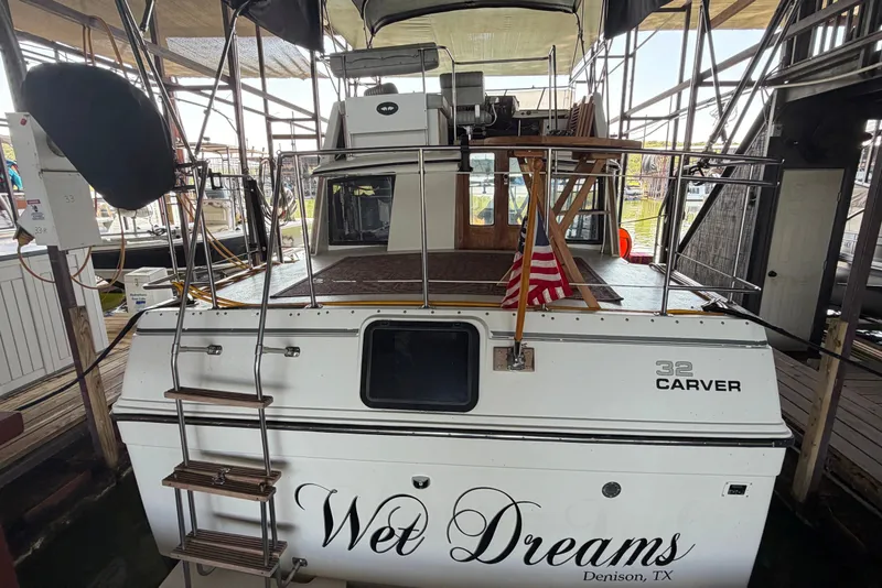 Slide: The Image of 1987 Carver 32 Aft Cabin Motor Yacht docked, rear view with American flag. - 1