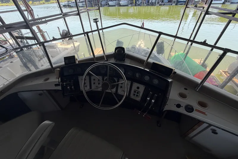 Slide: The Image of 1987 Carver 32 Aft Cabin Motor Yacht helm with steering wheel and controls. - 10