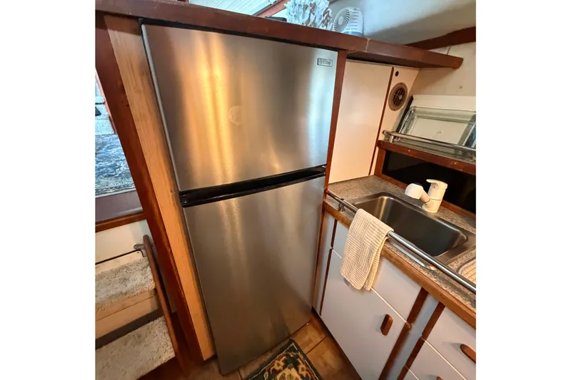 Slide: The Image of Compact kitchen area in 1987 Carver 32 Aft Cabin Motor Yacht with stainless steel fridge. - 27