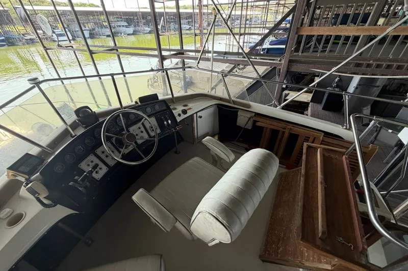 Slide: The Image of 1987 Carver 32 Aft Cabin Motor Yacht helm with steering wheel and controls in marina. - 15