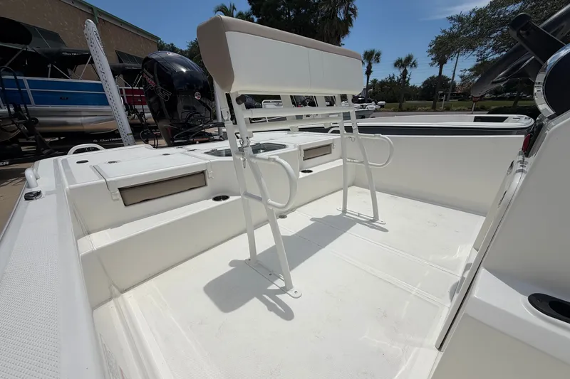 Slide: The Image of 2026 Mako Pro Skiff 19 CC boat interior with seating and motor, under sunny skies. - 6
