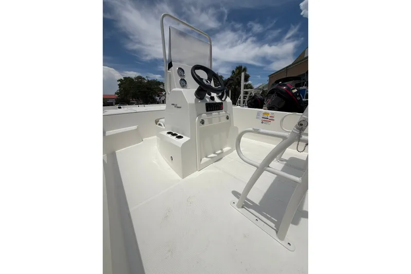 Slide: The Image of 2026 Mako Pro Skiff 19 CC boat interior with steering console under a clear sky. - 3