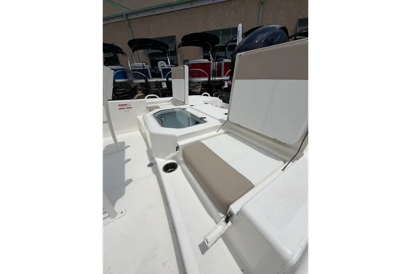 Slide: The Image of 2026 Mako Pro Skiff 19 CC boat interior with seating and storage compartment. - 4