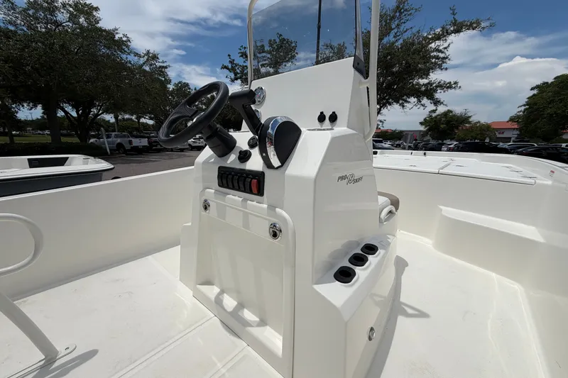 Slide: The Image of 2026 Mako Pro Skiff 19 CC boat console with steering wheel and controls. - 7