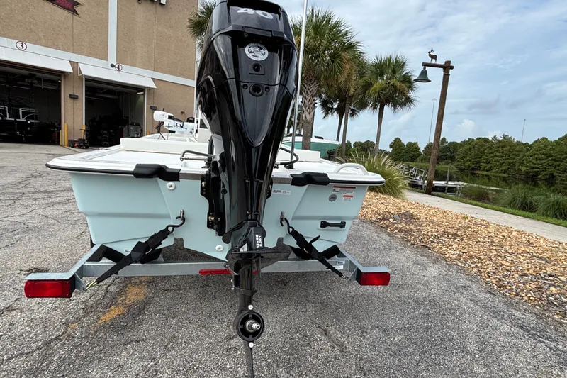 Slide: The Image of 2026 Mako Pro Skiff 13 CC boat on trailer, parked near a waterfront area. - 3