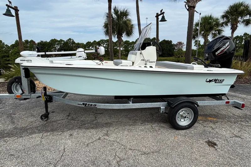 The Image of 2026 Mako Pro Skiff 13 CC boat on trailer, featuring Minn Kota motor and Mercury engine. - 0