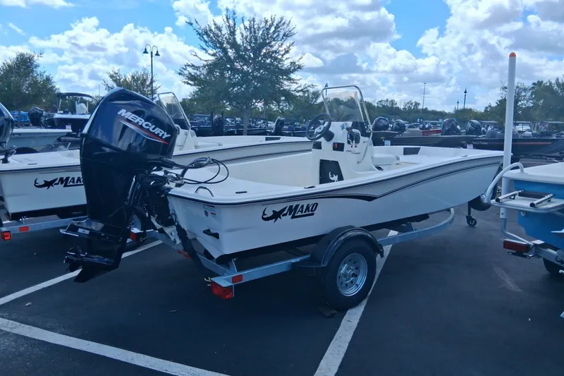 The Image of 2026 Mako Pro Skiff 15 CC boat with Mercury engine on trailer, parked outdoors. - 0