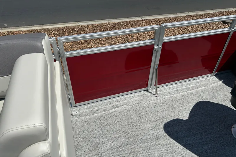 Slide: The Image of 2026 Sun Tracker Fishin' Barge 22 DLX interior with red paneling and gray seating. - 31