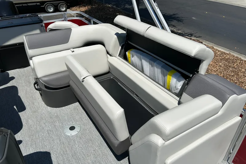 Slide: The Image of 2026 Sun Tracker Fishin' Barge 22 DLX interior seating with storage compartment open. - 15