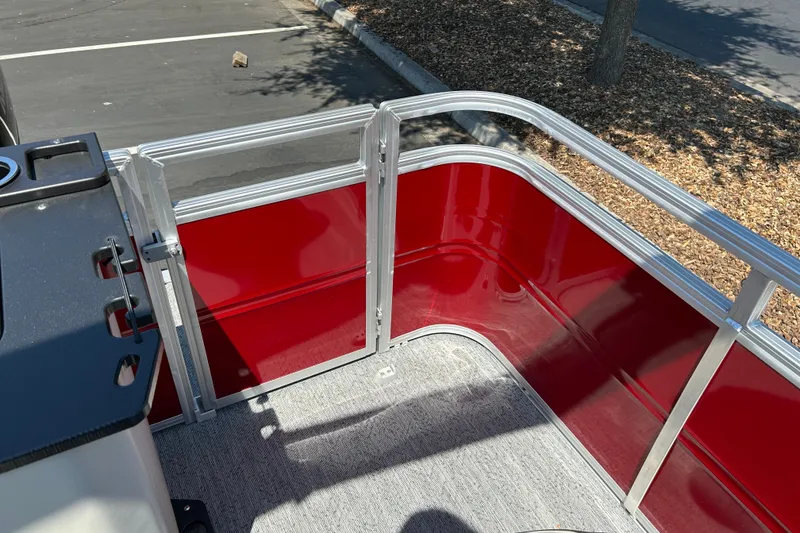 Slide: The Image of 2026 Sun Tracker Fishin' Barge 22 DLX, red interior, aluminum railing, outdoor setting. - 29