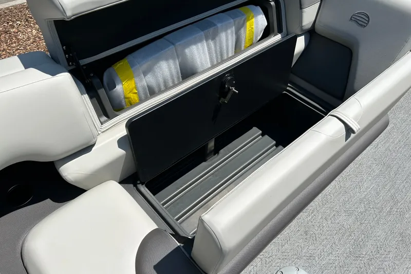 Slide: The Image of 2026 Sun Tracker Fishin' Barge 22 DLX storage compartment with cushioned seating. - 17