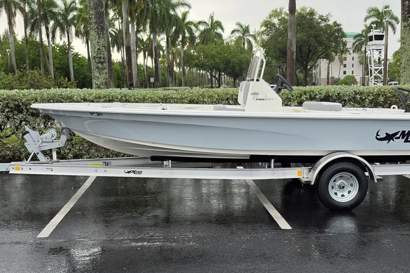 The Image of 2026 Mako 18 Pro Skiff boat on trailer in a tropical parking lot. - 0