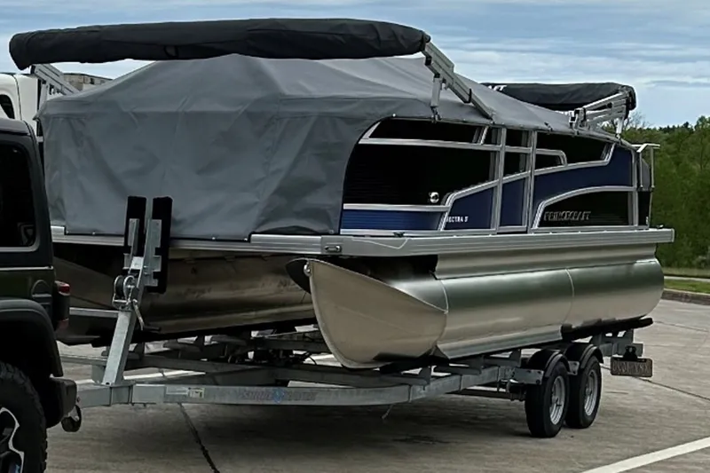 Slide: The Image of 2024 Princecraft Vectra 21 RL pontoon boat on trailer, covered and ready for transport. - 1