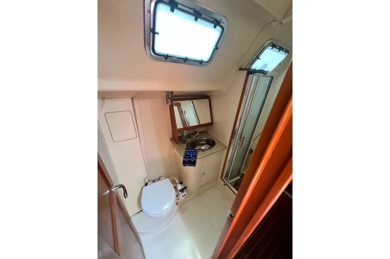 Slide: The Image of Bathroom interior of 2007 Hunter 41 Deck Salon yacht, featuring toilet, sink, and shower. - 80