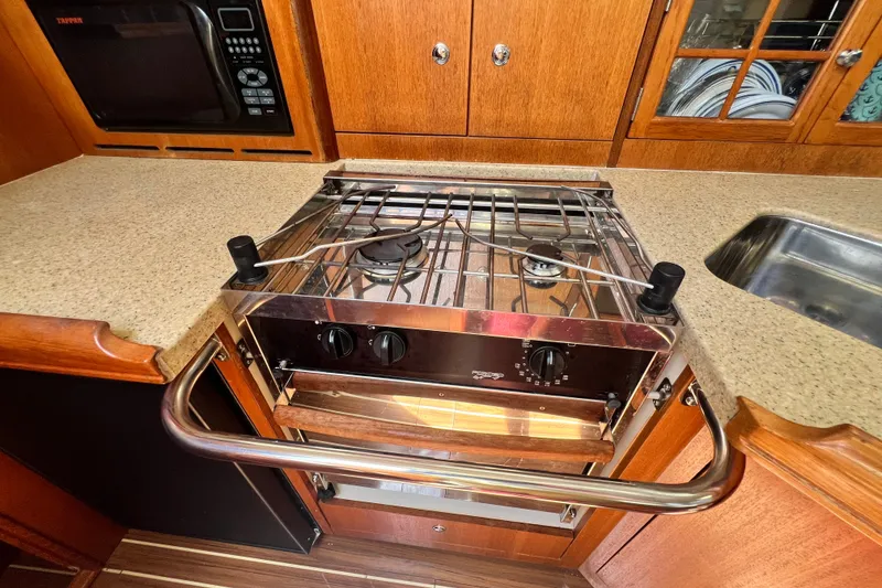 Slide: The Image of 2007 Hunter 41 Deck Salon kitchen with stove, microwave, and sink. - 60