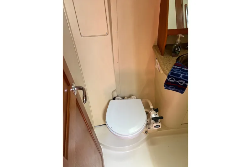 Slide: The Image of Bathroom interior of 2007 Hunter 41 Deck Salon yacht, featuring a compact marine toilet. - 79