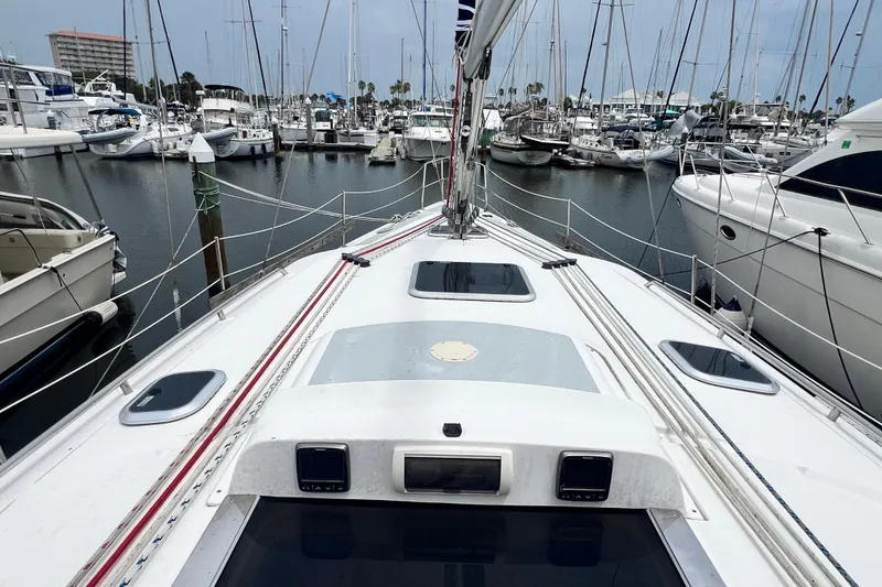 Slide: The Image of 2007 Hunter 41 Deck Salon sailboat docked in a marina, surrounded by other boats. - 23
