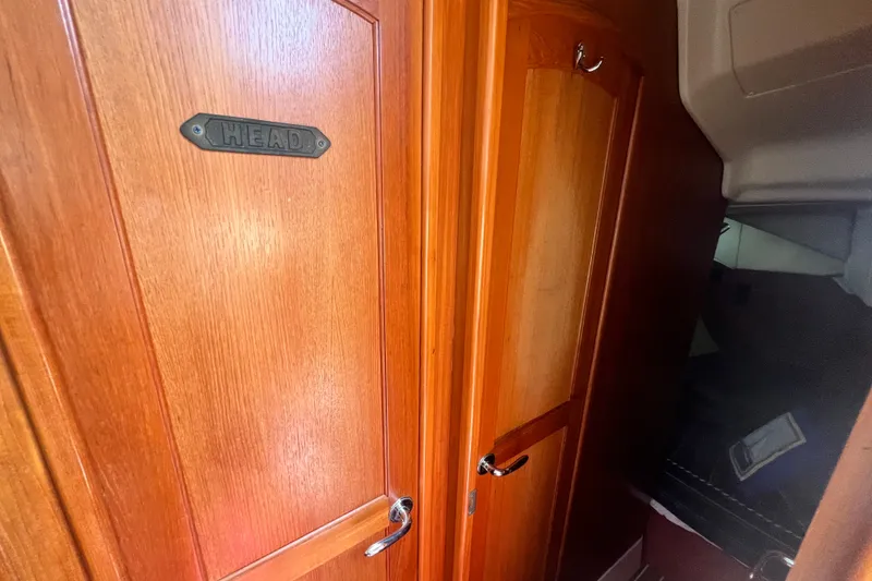 Slide: The Image of Interior view of 2007 Hunter 41 Deck Salon, featuring wooden doors and "Head" sign. - 78