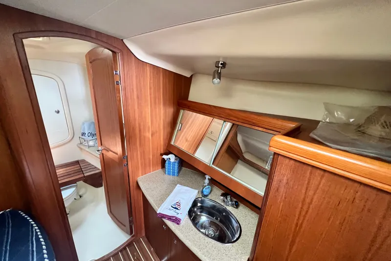 Slide: The Image of Interior of 2007 Hunter 41 Deck Salon yacht bathroom with wood finish and sink. - 68