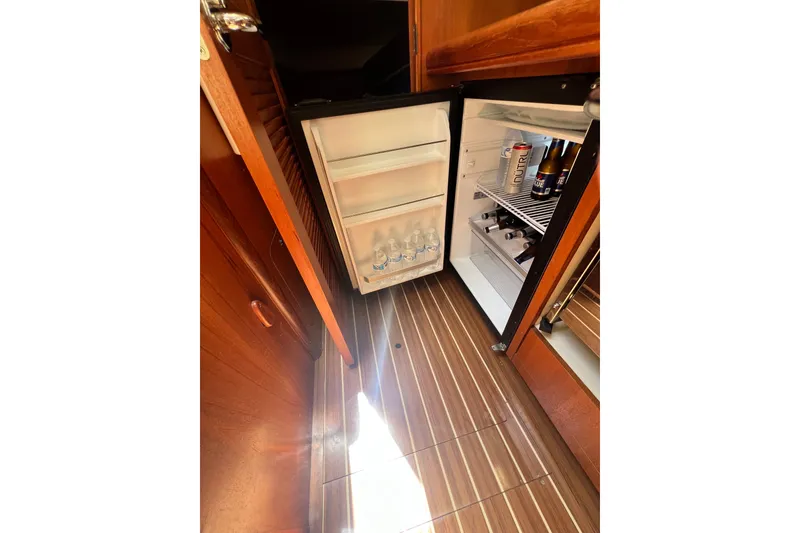 Slide: The Image of Open fridge in 2007 Hunter 41 Deck Salon yacht, stocked with beverages, on wooden flooring. - 62