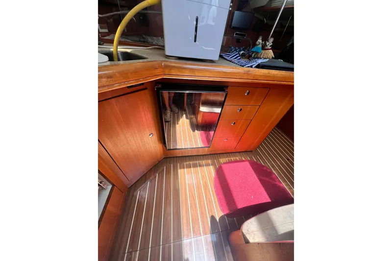 Slide: The Image of Interior of 2007 Hunter 41 Deck Salon with wooden cabinetry and stainless steel fridge. - 63