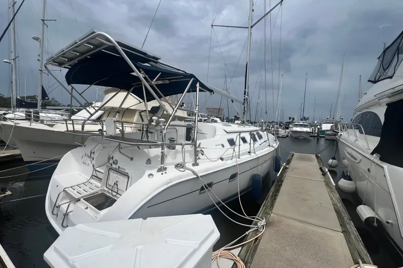 The Image of 2007 Hunter 41 Deck Salon yacht docked at marina under cloudy sky. - 0