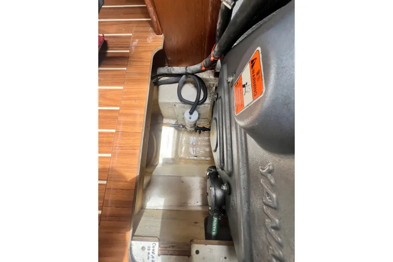 Slide: The Image of Engine compartment of 2007 Hunter 41 Deck Salon sailboat, showcasing mechanical components and wooden flooring. - 93