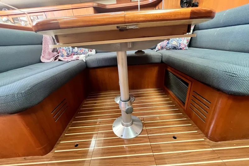 Slide: The Image of Interior of 2007 Hunter 41 Deck Salon with wooden table and cushioned seating. - 58
