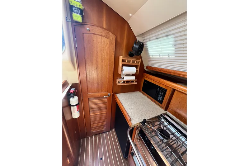 Slide: The Image of 2007 Hunter 41 Deck Salon interior kitchen with wooden cabinetry and modern appliances. - 74