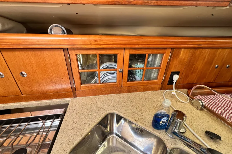 Slide: The Image of Interior of 2007 Hunter 41 Deck Salon showing kitchen sink and wooden cabinets. - 61
