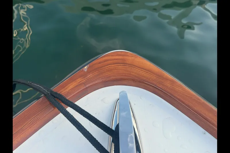 Slide: The Image of Bow of 2019 Albury Brothers 23 Forward Seating boat with wooden trim and water reflection. - 20