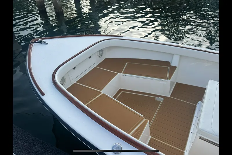 Slide: The Image of 2019 Albury Brothers 23 Forward Seating boat with tan cushions, docked on calm water. - 6