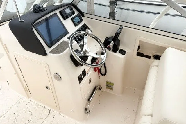 Slide: The Image of 2023 Grady-White Freedom 255 boat helm with steering wheel and control panel. - 19