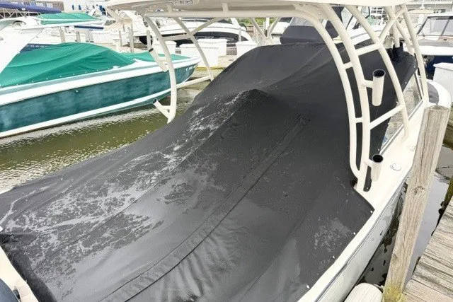 Slide: The Image of 2023 Grady-White Freedom 255 boat with black cover docked at marina. - 25