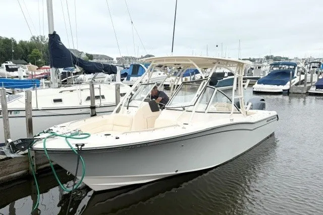 The Image of 2023 Grady-White Freedom 255 boat docked in a marina, surrounded by other vessels. - 0
