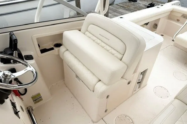 Slide: The Image of 2023 Grady-White Freedom 255 boat interior with plush seating and steering wheel. - 18