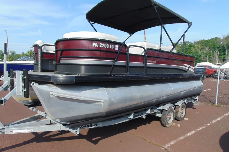 Slide: The Image of 2022 Godfrey Sweetwater 2186 FS pontoon boat on trailer, parked outdoors. - 2