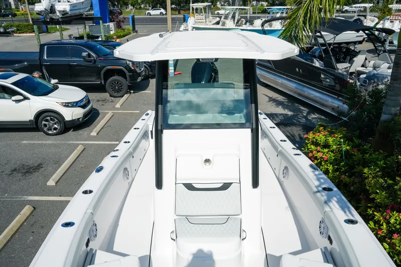 Slide: The Image of 2027 Blackfin 262 HB boat in a marina parking lot, surrounded by vehicles and greenery. - 24