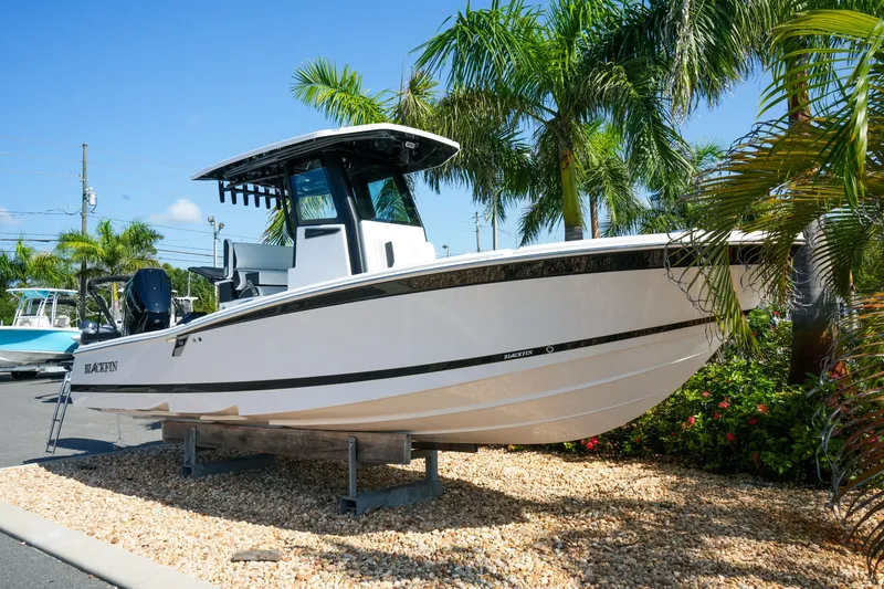 Slide: The Image of 2027 Blackfin 262 HB boat displayed outdoors with palm trees. - 2