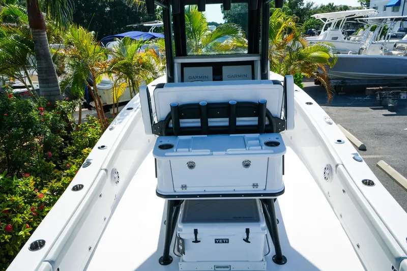 Slide: The Image of 2027 Blackfin 262 HB boat interior with Garmin electronics and Yeti cooler, surrounded by tropical plants. - 11