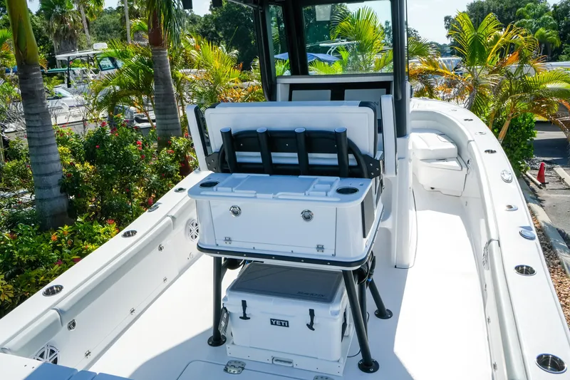 Slide: The Image of 2027 Blackfin 262 HB boat interior with seating and storage, surrounded by lush greenery. - 8